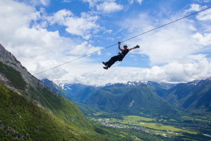 Zipline above an alpine valley with village below